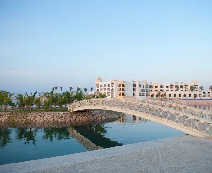 Arched bridge over the lagoon with the resort in the distance